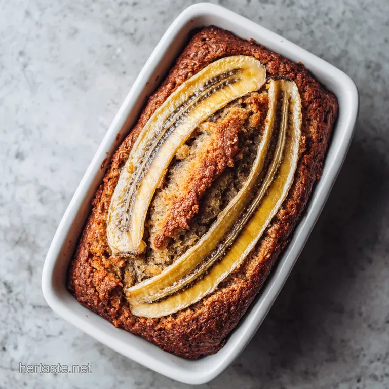 Slices of banana bread on a white plate, lightly dusted with powdered sugar. A sprig of mint adds a touch of freshness.